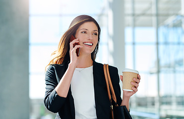 Image showing Your jackpot might just be a phone call away. an attractive young businesswoman taking a a phonecall while walking through a modern office.