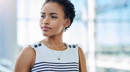 Image showing Big plans in that beautiful mind. an attractive young businesswoman looking thoughtful while standing in a modern office.