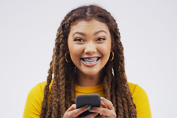 Image showing Online is an exciting place to be. Studio shot of a young woman looking excited while using her cellphone.