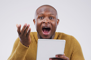 Image showing I have no idea how I won this online competition. Studio shot of a young man looking surprised while using a digital tablet.