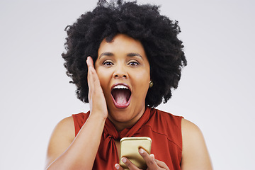 Image showing Online shopping is one of the big advantages of the internet. Studio shot of a young woman looking surprised while reading something on her cellphone.