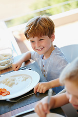 Image showing Lunchtime. a little boy enjoying a meal with his family at home.