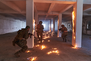 Image showing A group of professional soldiers bravely executes a dangerous rescue mission, surrounded by fire in a perilous building.