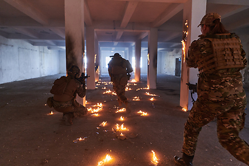 Image showing A group of professional soldiers bravely executes a dangerous rescue mission, surrounded by fire in a perilous building.