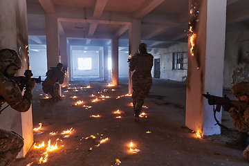 Image showing A group of professional soldiers bravely executes a dangerous rescue mission, surrounded by fire in a perilous building.