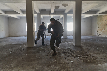 Image showing A group of professional soldiers bravely executes a dangerous rescue mission, surrounded by fire in a perilous building.