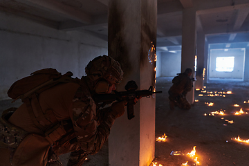 Image showing A group of professional soldiers bravely executes a dangerous rescue mission, surrounded by fire in a perilous building.