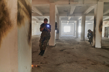 Image showing A group of professional soldiers bravely executes a dangerous rescue mission, surrounded by fire in a perilous building.