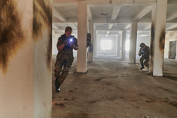 Image showing A group of professional soldiers bravely executes a dangerous rescue mission, surrounded by fire in a perilous building.