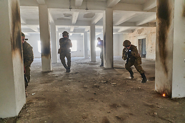 Image showing A group of professional soldiers bravely executes a dangerous rescue mission, surrounded by fire in a perilous building.