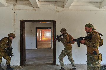 Image showing A group of professional soldiers bravely executes a dangerous rescue mission, surrounded by fire in a perilous building.