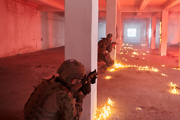 Image showing A group of professional soldiers bravely executes a dangerous rescue mission, surrounded by fire in a perilous building.