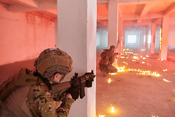 Image showing A group of professional soldiers bravely executes a dangerous rescue mission, surrounded by fire in a perilous building.