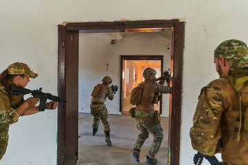 Image showing A group of professional soldiers bravely executes a dangerous rescue mission, surrounded by fire in a perilous building.