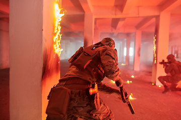 Image showing A group of professional soldiers bravely executes a dangerous rescue mission, surrounded by fire in a perilous building.