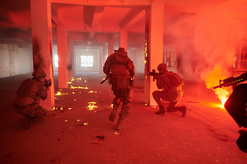 Image showing A group of professional soldiers bravely executes a dangerous rescue mission, surrounded by fire in a perilous building.