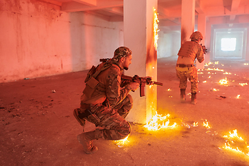 Image showing A group of professional soldiers bravely executes a dangerous rescue mission, surrounded by fire in a perilous building.