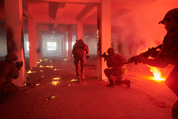 Image showing A group of professional soldiers bravely executes a dangerous rescue mission, surrounded by fire in a perilous building.