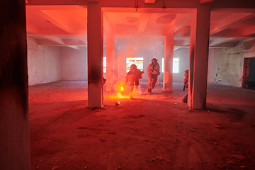 Image showing A group of professional soldiers bravely executes a dangerous rescue mission, surrounded by fire in a perilous building.