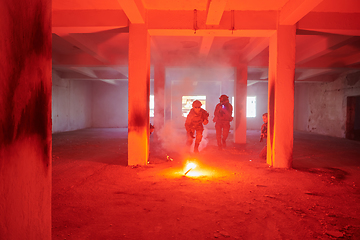 Image showing A group of professional soldiers bravely executes a dangerous rescue mission, surrounded by fire in a perilous building.