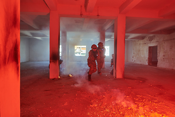 Image showing A group of professional soldiers bravely executes a dangerous rescue mission, surrounded by fire in a perilous building.