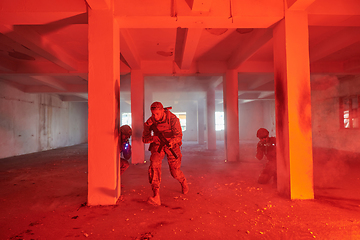 Image showing A group of professional soldiers bravely executes a dangerous rescue mission, surrounded by fire in a perilous building.