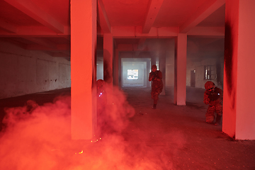 Image showing A group of professional soldiers bravely executes a dangerous rescue mission, surrounded by fire in a perilous building.