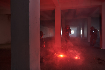 Image showing A group of professional soldiers bravely executes a dangerous rescue mission, surrounded by fire in a perilous building.