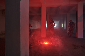 Image showing A group of professional soldiers bravely executes a dangerous rescue mission, surrounded by fire in a perilous building.