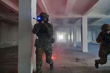 Image showing A group of professional soldiers bravely executes a dangerous rescue mission, surrounded by fire in a perilous building.