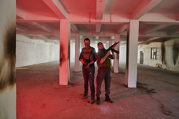 Image showing An abandoned building serves as the stronghold for a team of terrorists, fiercely guarding their occupied territory with guns and military equipment