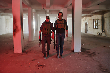 Image showing An abandoned building serves as the stronghold for a team of terrorists, fiercely guarding their occupied territory with guns and military equipment