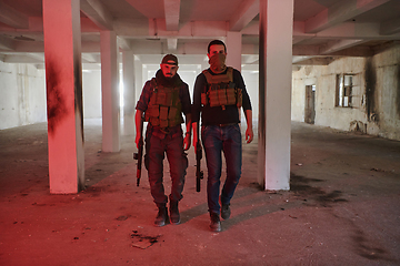 Image showing An abandoned building serves as the stronghold for a team of terrorists, fiercely guarding their occupied territory with guns and military equipment