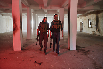 Image showing An abandoned building serves as the stronghold for a team of terrorists, fiercely guarding their occupied territory with guns and military equipment