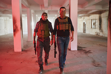 Image showing An abandoned building serves as the stronghold for a team of terrorists, fiercely guarding their occupied territory with guns and military equipment