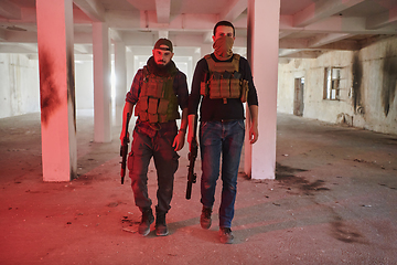 Image showing An abandoned building serves as the stronghold for a team of terrorists, fiercely guarding their occupied territory with guns and military equipment