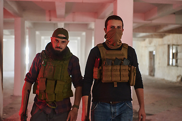 Image showing An abandoned building serves as the stronghold for a team of terrorists, fiercely guarding their occupied territory with guns and military equipment