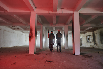 Image showing An abandoned building serves as the stronghold for a team of terrorists, fiercely guarding their occupied territory with guns and military equipment