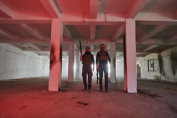 Image showing An abandoned building serves as the stronghold for a team of terrorists, fiercely guarding their occupied territory with guns and military equipment