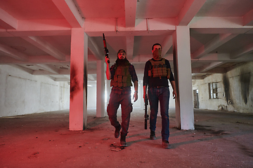 Image showing An abandoned building serves as the stronghold for a team of terrorists, fiercely guarding their occupied territory with guns and military equipment