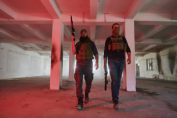 Image showing An abandoned building serves as the stronghold for a team of terrorists, fiercely guarding their occupied territory with guns and military equipment