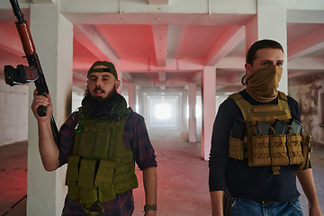 Image showing An abandoned building serves as the stronghold for a team of terrorists, fiercely guarding their occupied territory with guns and military equipment