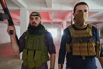 Image showing An abandoned building serves as the stronghold for a team of terrorists, fiercely guarding their occupied territory with guns and military equipment