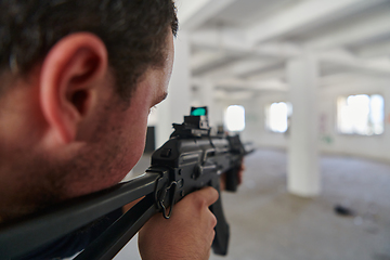 Image showing In an abandoned building, a terrorist takes aim with a rifle at a military opponent, engaged in a fierce battle for territorial control, embodying the dangers and tensions of the conflict.