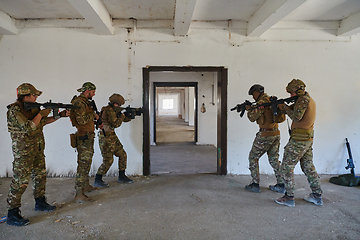 Image showing A group of professional soldiers bravely executes a dangerous rescue mission, surrounded by fire in a perilous building.