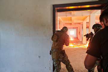 Image showing A group of professional soldiers bravely executes a dangerous rescue mission, surrounded by fire in a perilous building.