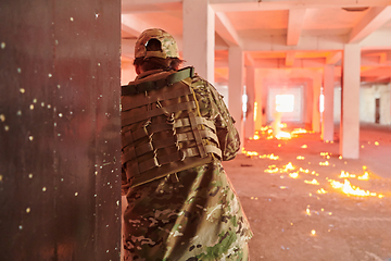 Image showing A group of professional soldiers bravely executes a dangerous rescue mission, surrounded by fire in a perilous building.