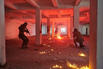 Image showing A group of professional soldiers bravely executes a dangerous rescue mission, surrounded by fire in a perilous building.