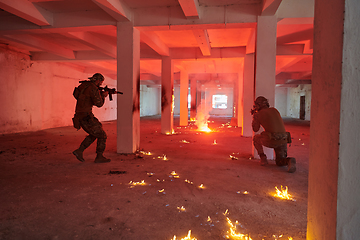 Image showing A group of professional soldiers bravely executes a dangerous rescue mission, surrounded by fire in a perilous building.