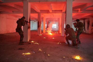 Image showing A group of professional soldiers bravely executes a dangerous rescue mission, surrounded by fire in a perilous building.